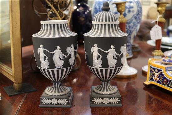 A pair of Wedgwood black jasper urn shaped vases and a cover, c.1913, height 10.5in.